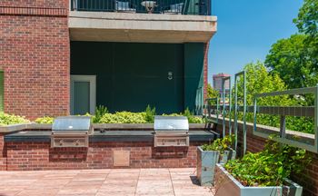 a patio with plants and a building in the background